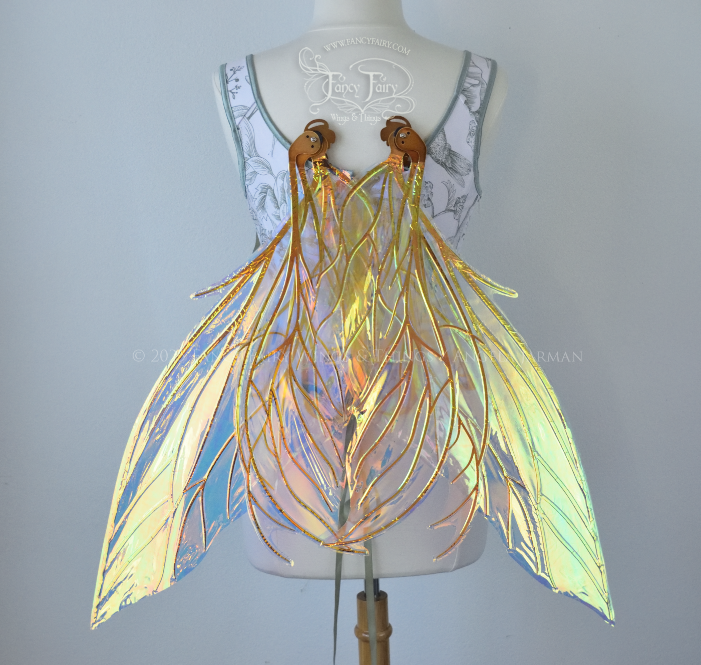 Large transparent iridescent orange/yellow/green dragonfly-like iridescent fairy wings with copper veins have 3 elongated panels on each side, worn on a dress form, back view in resting position