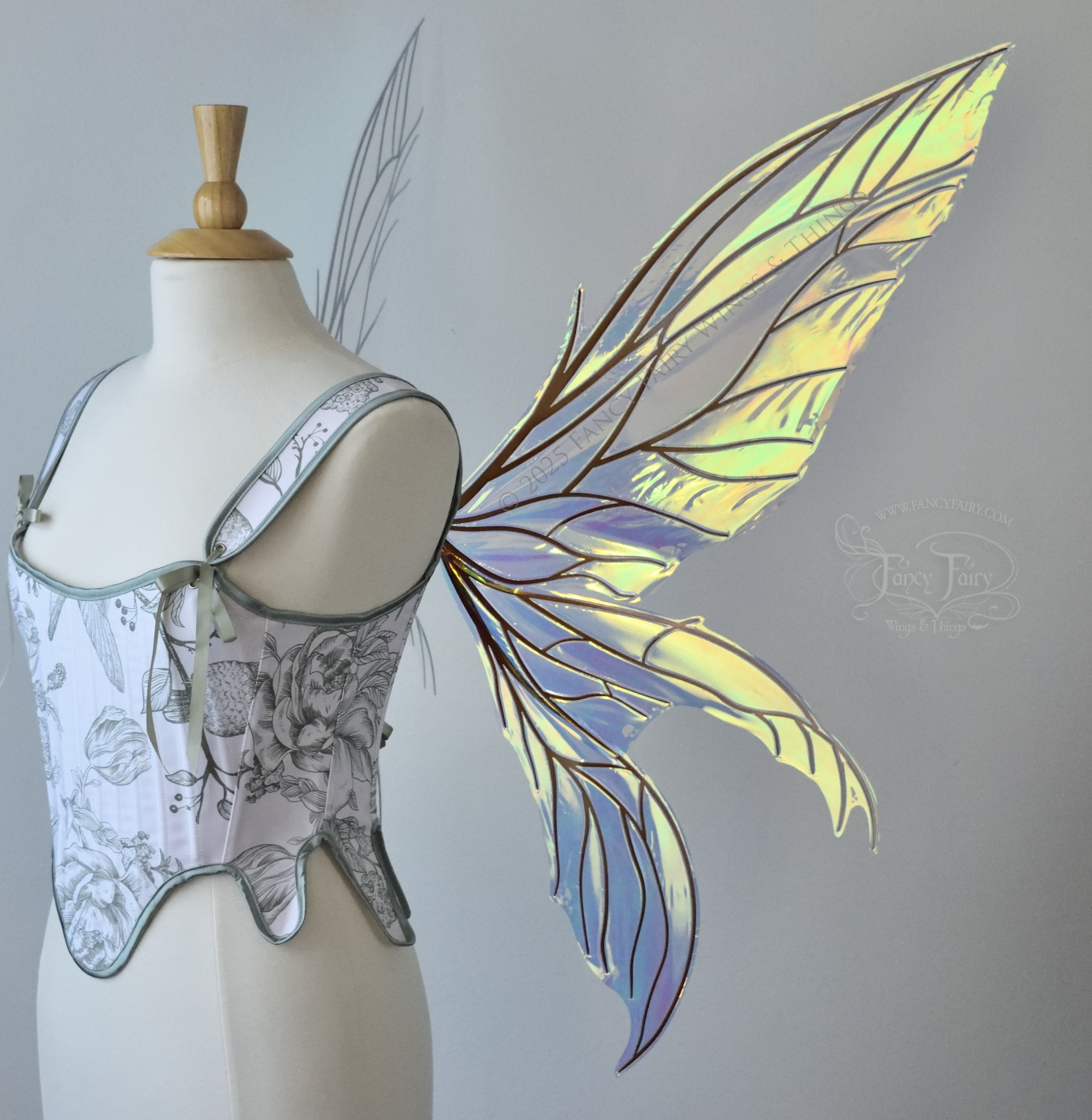 Large transparent iridescent orange/yellow/green dragonfly-like iridescent fairy wings with copper veins have 3 elongated panels on each side, worn on a dress form, right side view