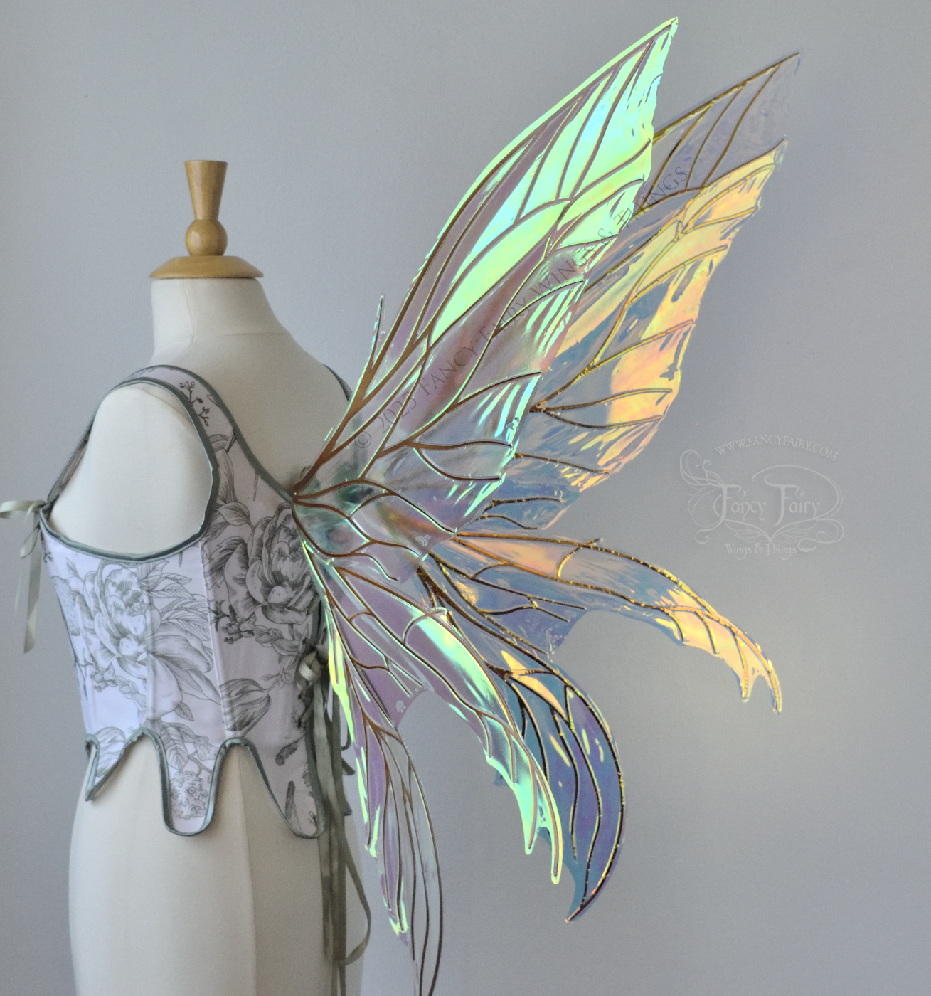 Large transparent iridescent orange/yellow/green dragonfly-like iridescent fairy wings with copper veins have 3 elongated panels on each side, worn on a dress form, back 3/4 view
