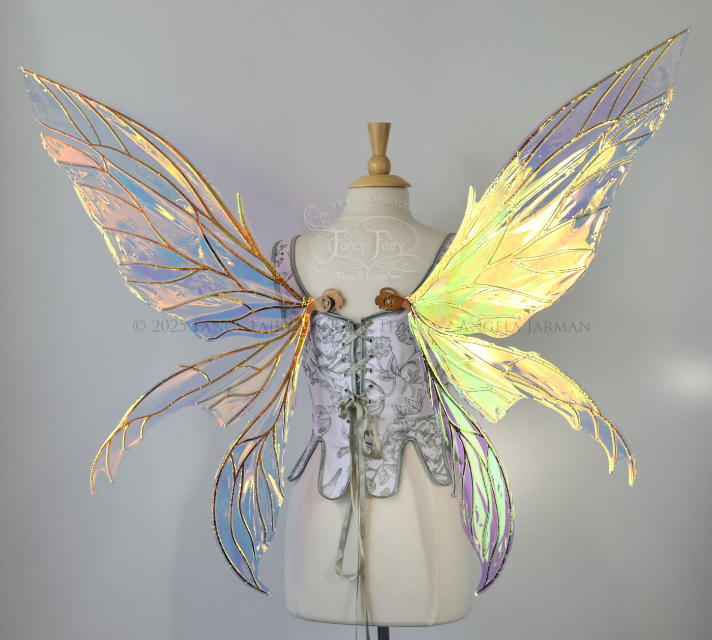 Large transparent iridescent orange/yellow/green dragonfly-like iridescent fairy wings with copper veins have 3 elongated panels on each side, worn on a dress form, back view