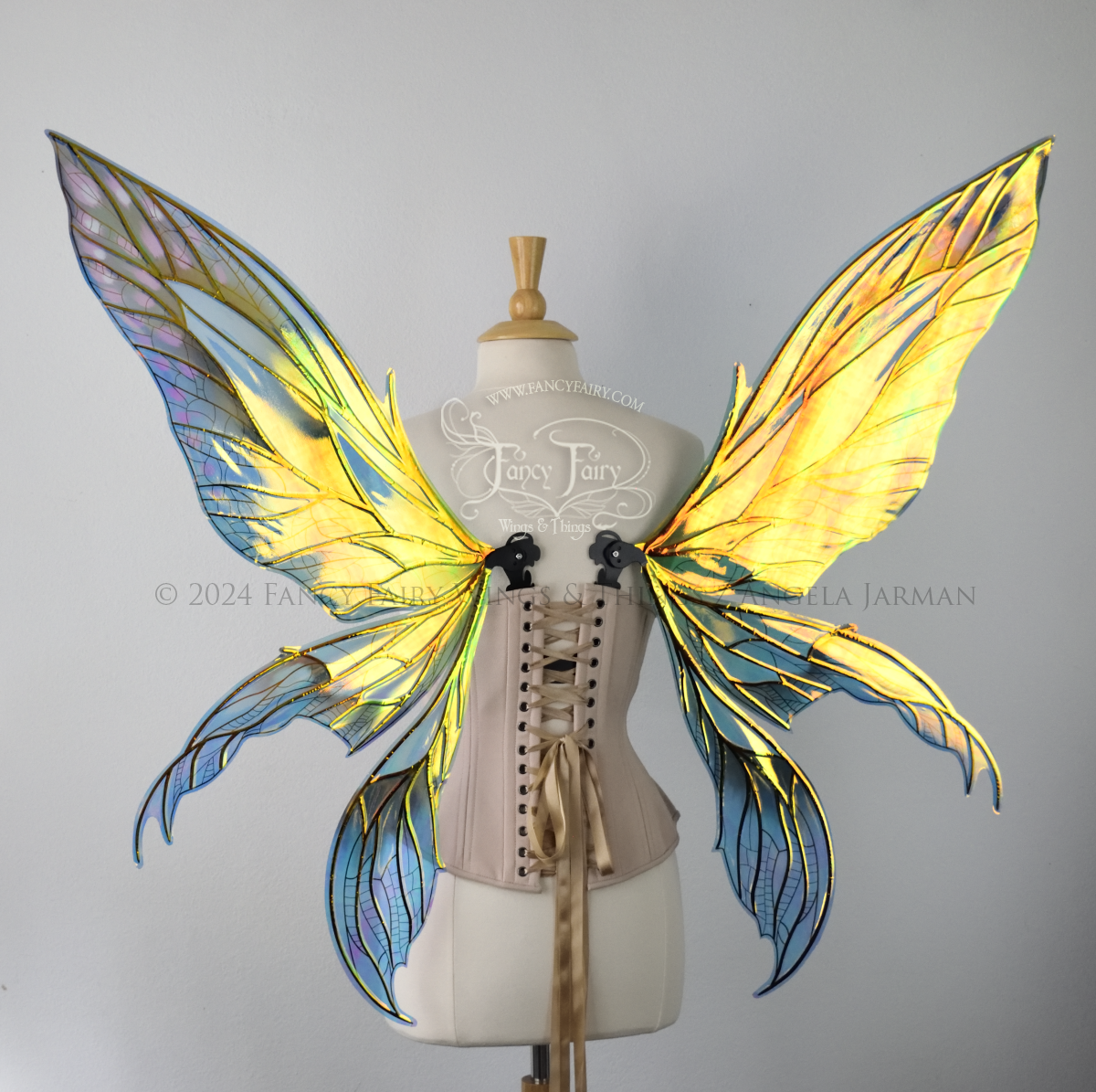Back view of large green and blue iridescent fairy wings with 3 panels on each side, pointed tips, lots of vein detail, worn on a dress form.