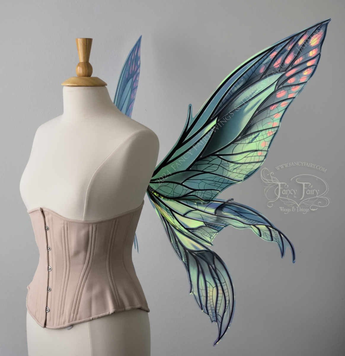 Right side view of large green & blue iridescent fairy wings with 3 panels on each side, pointed tips, lots of veins, worn on a dress form
