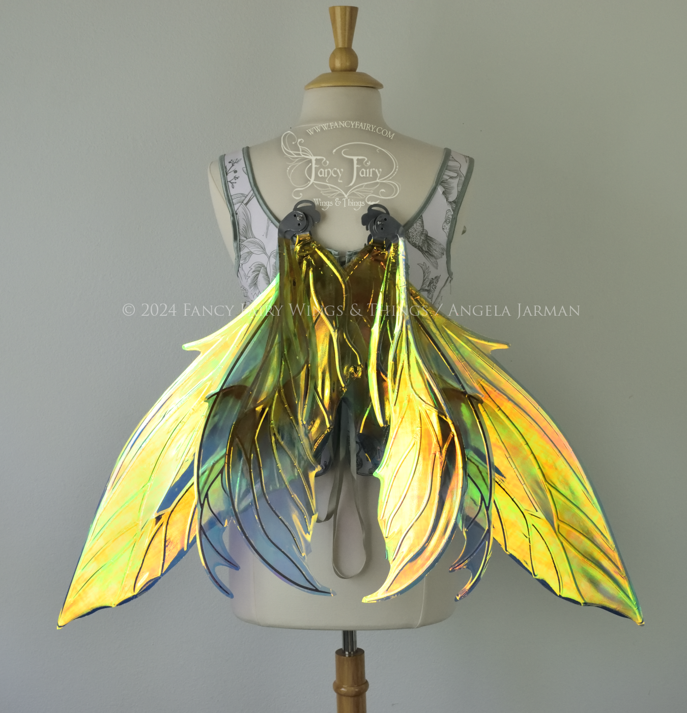 Large 'Fayette' large iridescent blue and green fairy wings with 3 panels on each side, pink dots near the upper panel tips, & silver veins, worn on a dress form, back view in resting position