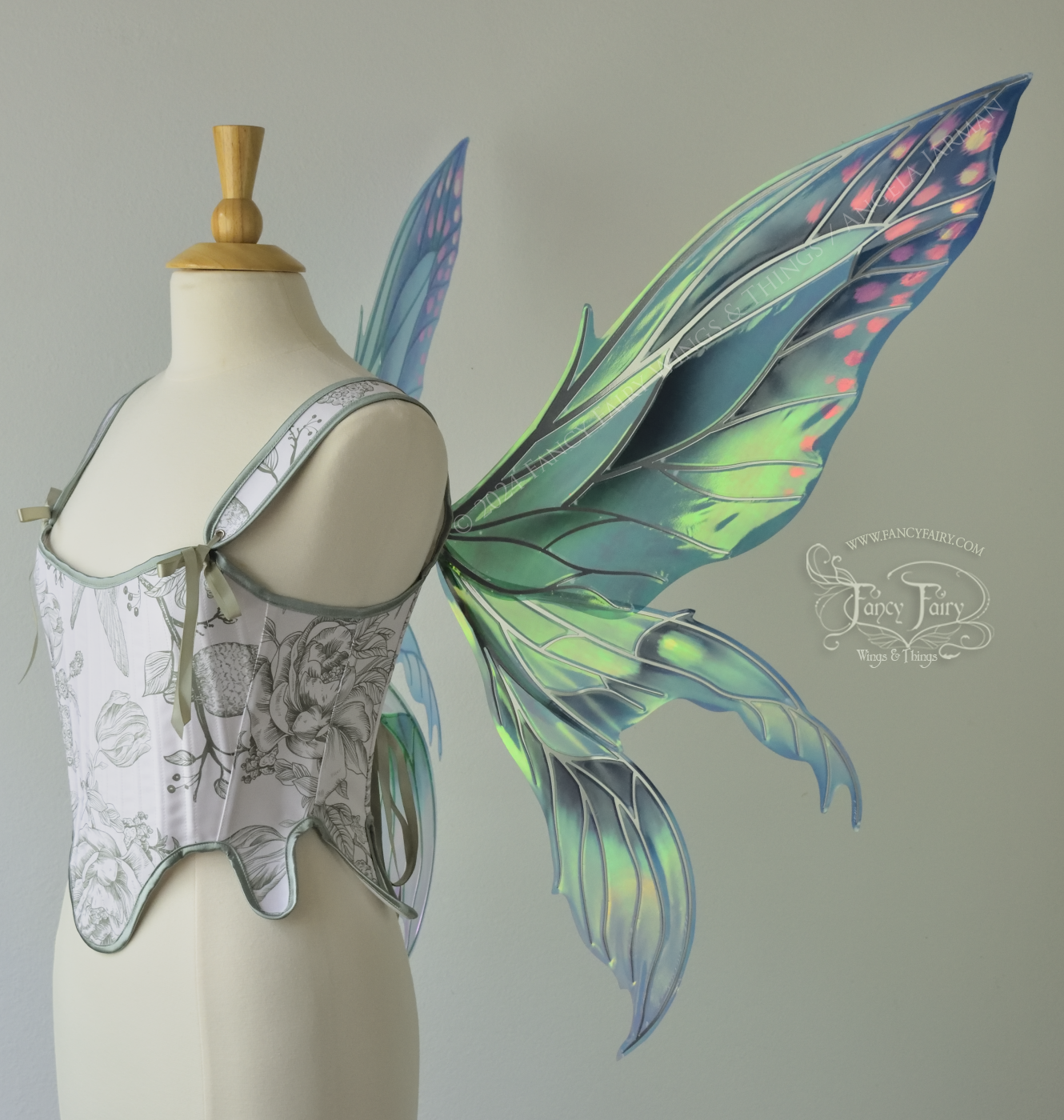 Large 'Fayette' large iridescent blue and green fairy wings with 3 panels on each side, pink dots near the upper panel tips, & silver veins, worn on a dress form, right side view