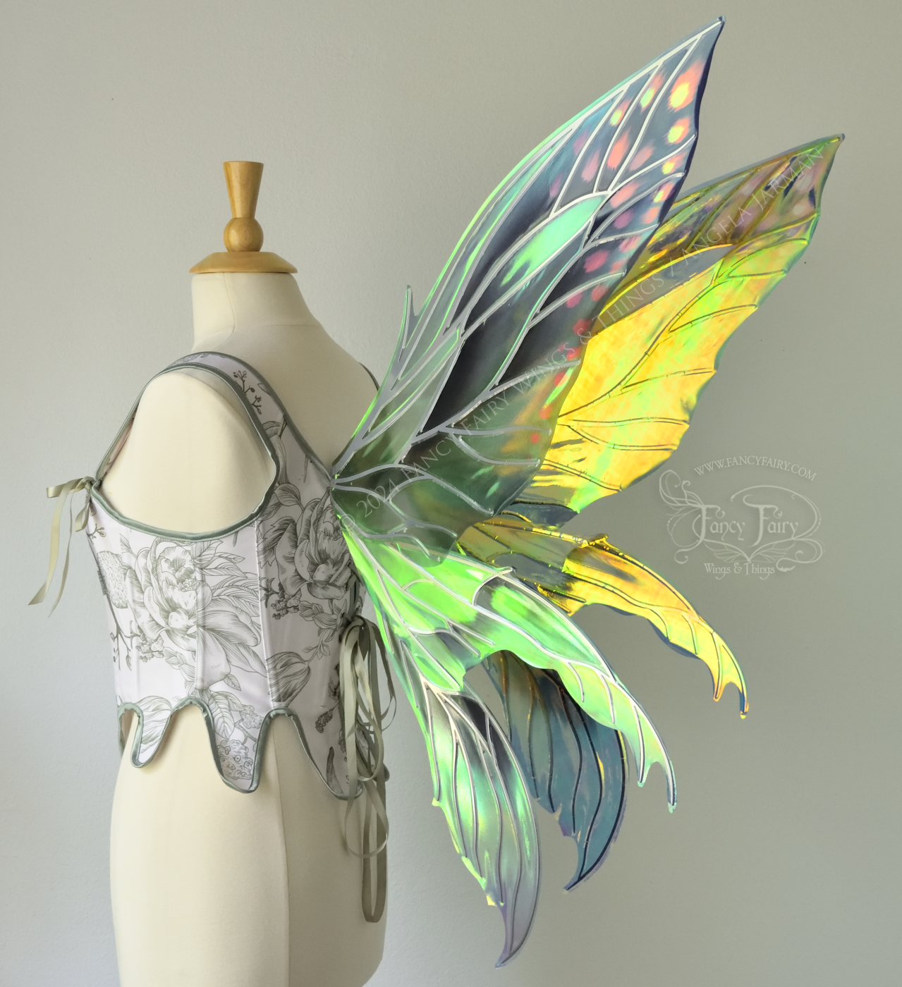 Large 'Fayette' large iridescent blue and green fairy wings with 3 panels on each side, pink dots near the upper panel tips, & silver veins, worn on a dress form, back 3/4 view