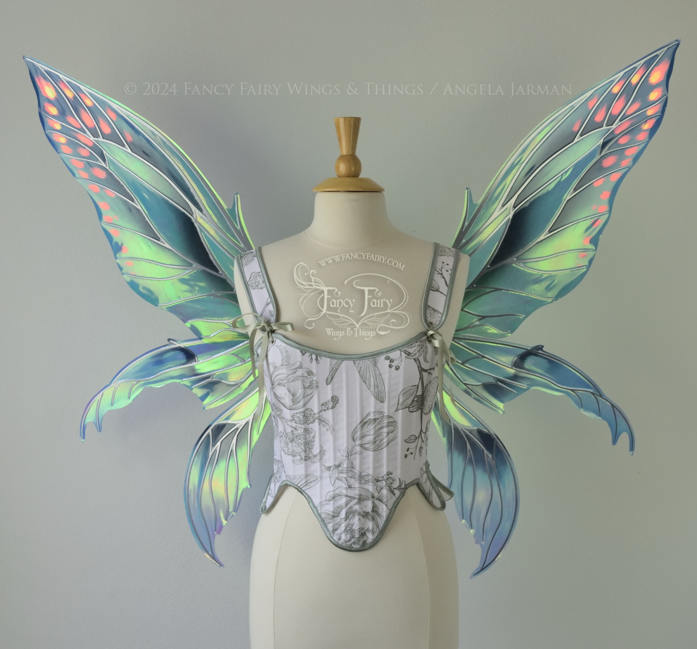 Large 'Fayette' large iridescent blue and green fairy wings with 3 panels on each side, pink dots near the upper panel tips, & silver veins, worn on a dress form, front view