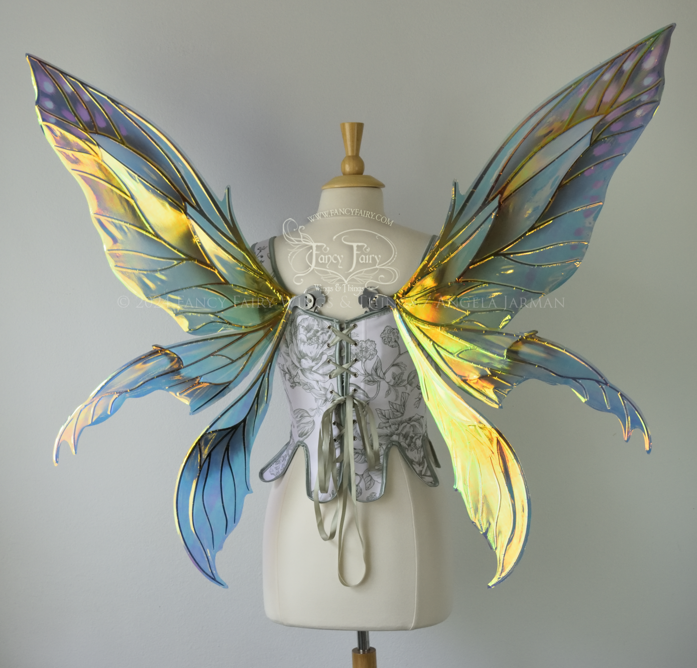 Large 'Fayette' large iridescent blue and green fairy wings with 3 panels on each side, pink dots near the upper panel tips, & silver veins, worn on a dress form, back view