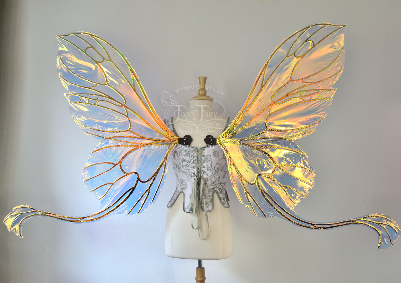 Gigantic transparent & yellow/green/orange iridescent butterfly shaped fairy wings with black veins and 'tails' that curve out from the bottom panels, worn on a dress form, back view