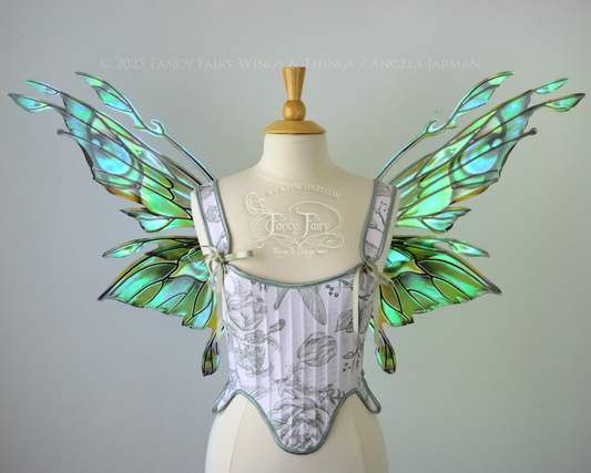 Iridescent green, blue and black fairy wings with antennae and small appendages sticking out from the tips, worn on a dress form, front view