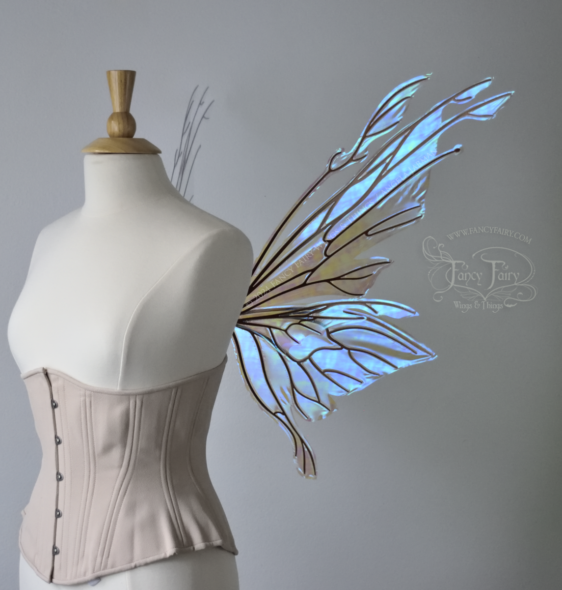 Large blue green iridescent fairy wings with copper veins worn with an alabaster corset on a dress form, right side view