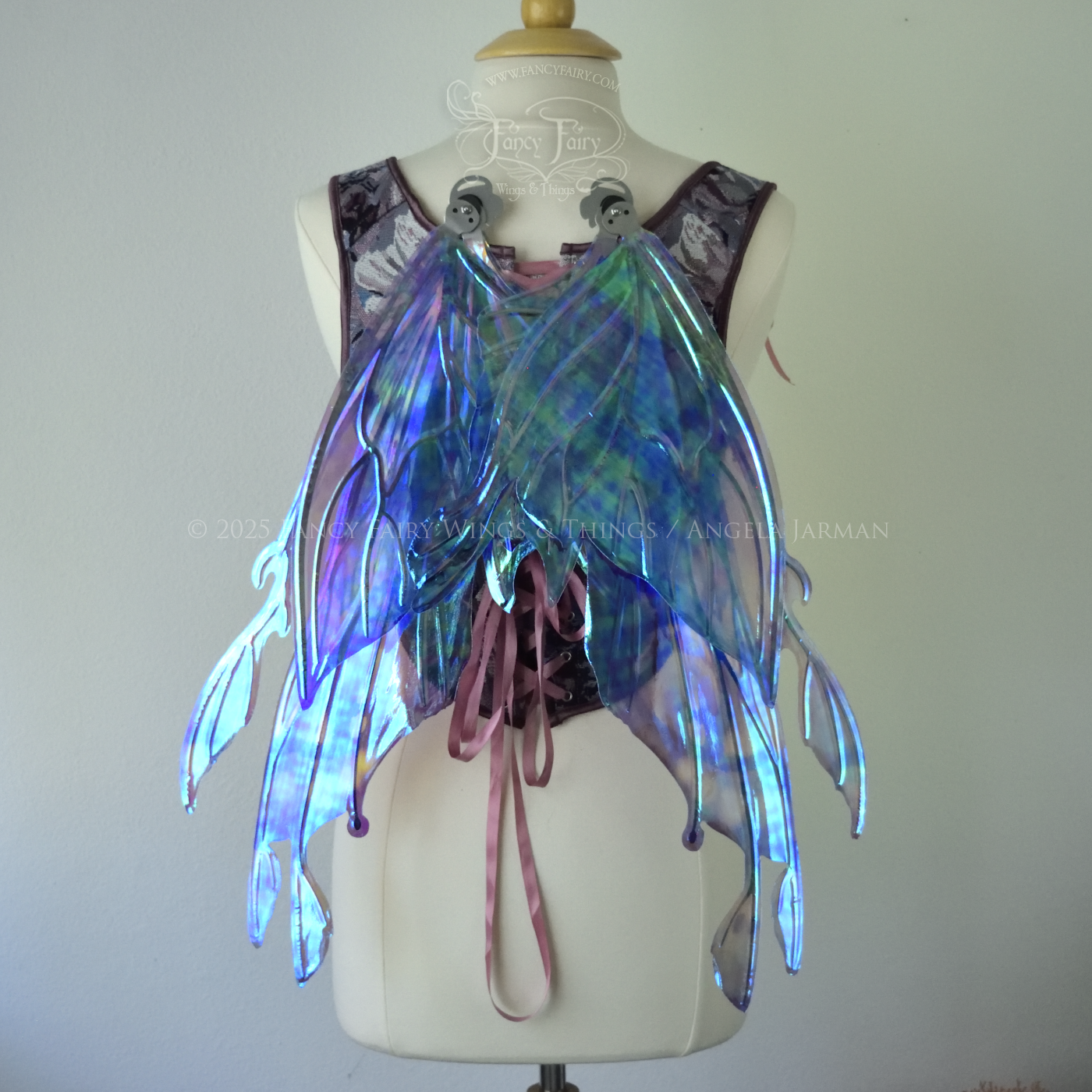Iridescent lavender, light blue and pink fairy wings with antennae and small appendages sticking out from the tips, the veins are silver, worn on a dress form, back view, in resting position