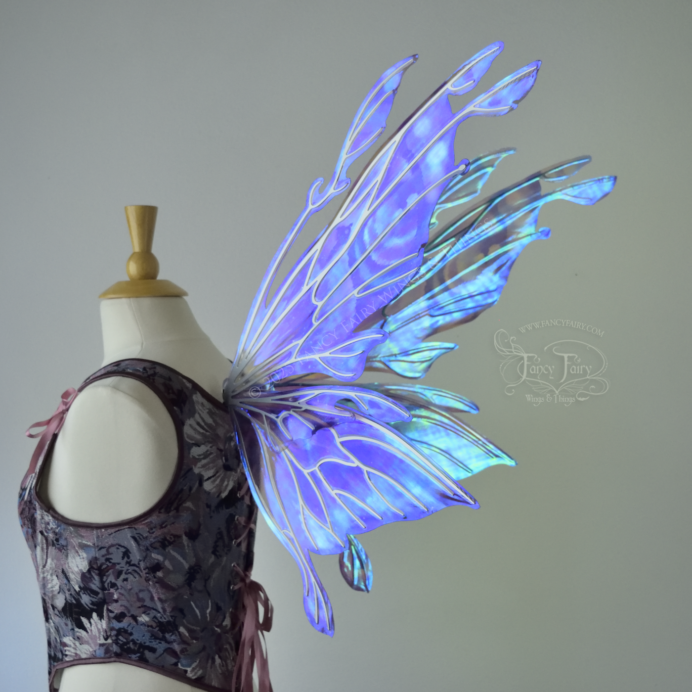 Iridescent lavender, light blue and pink fairy wings with antennae and small appendages sticking out from the tips, the veins are silver, worn on a dress form, right 3/4 back side view