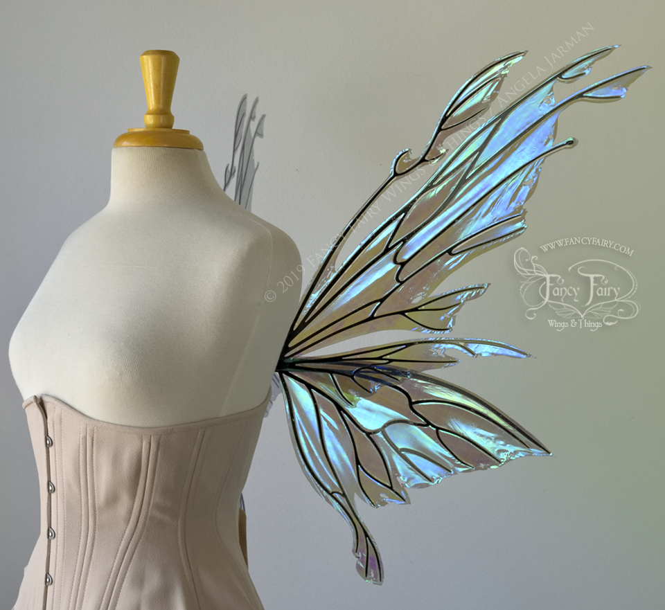 Right side view of an ivory dress form wearing an alabaster underbust corset & violet blue 'Dark Crystal' iridescent fairy wings with elongated upper panels with petal like appendages at the tips & antennae, the veins are black