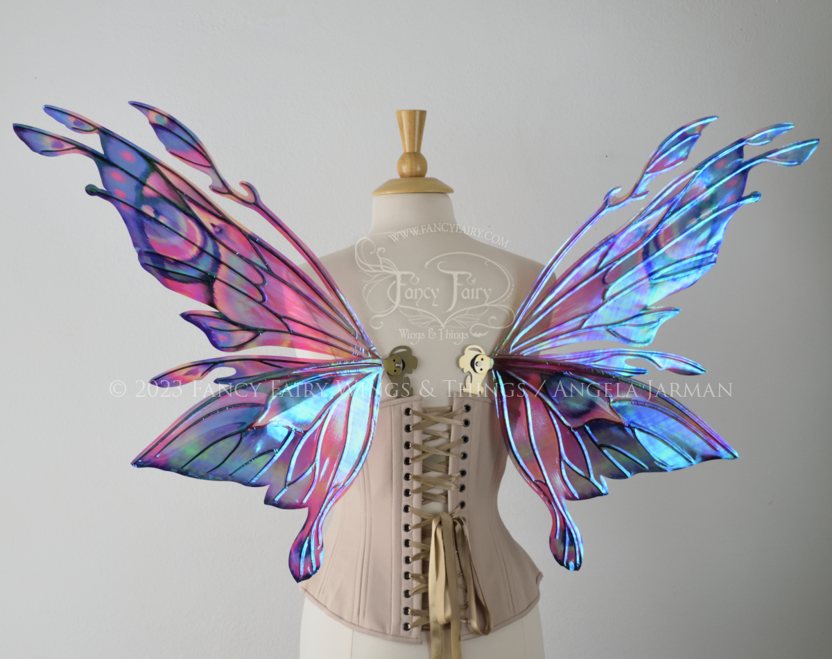 Back view of an ivory dress form wearing an underbust corset & 'Goblin Princess' magenta & blue painted iridescent wings w/ gold veins 