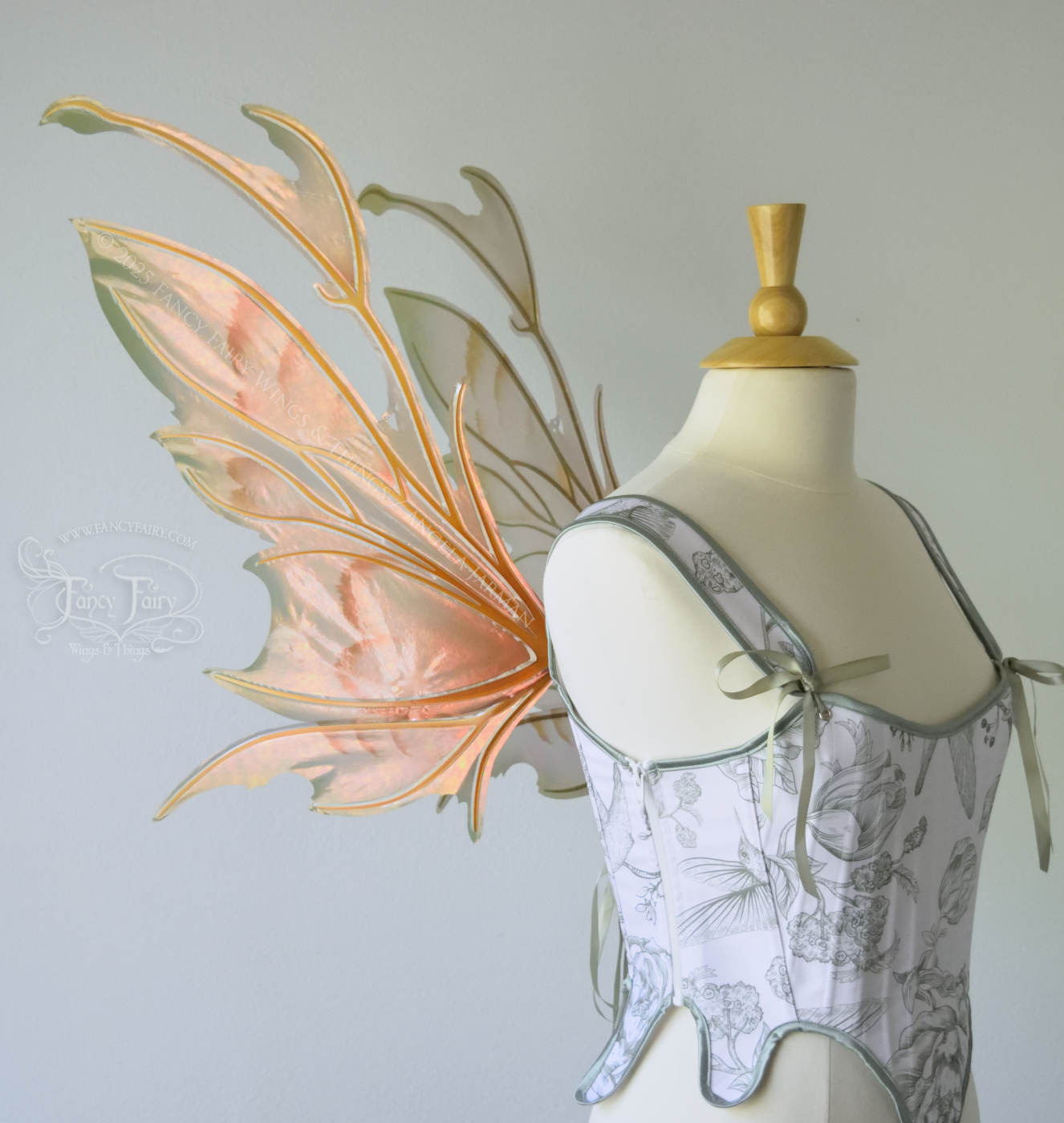 Rose Gold iridescent fairy wings with antennae and brown & olive green accents, copper veins, worn on a dress form, left side view