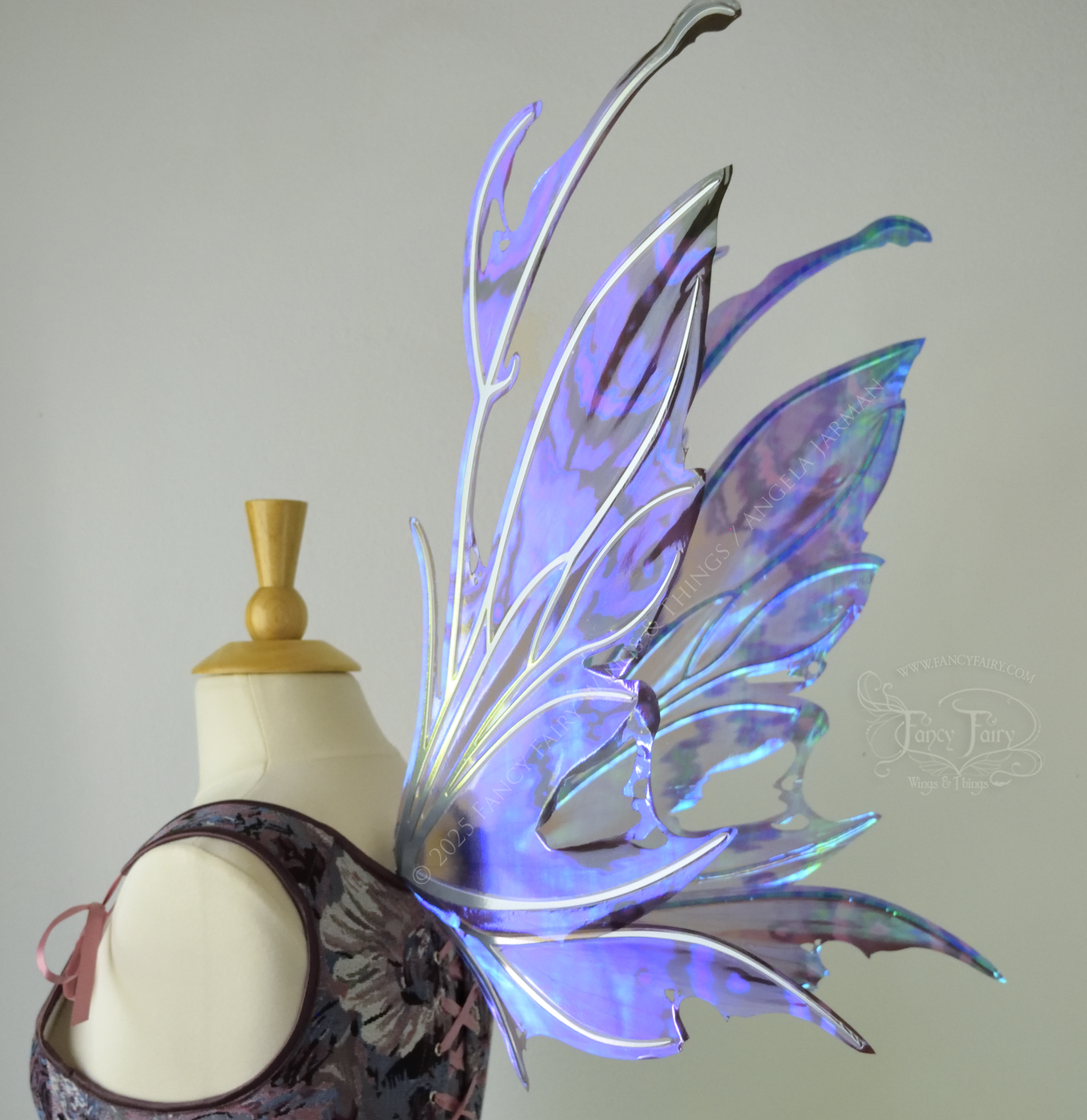 Purple & blue iridescent fairy wings with a spikey profile and antennae, with silver veins, are viewed from the back 3/4, worn on a dress form
