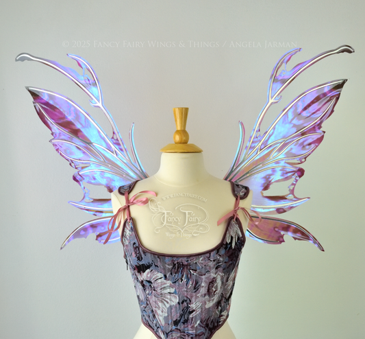 Purple & blue iridescent fairy wings with a spikey profile and antennae, with silver veins, are viewed from the front, worn on a dress form