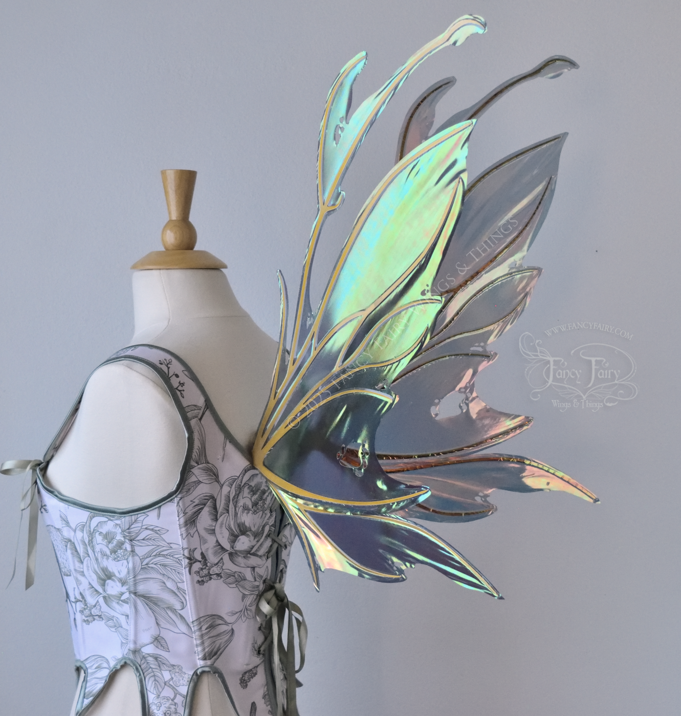 Dark orange / green & grey iridescent fairy wings with antennae and a spikey silhouette with tattered holes and gold veins, worn on a dress form, back 3/4 view