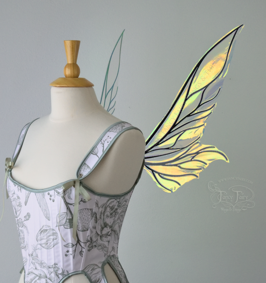 Iridescent green / orange / yellow fairy wings with elongated pointy upper panels and small leaf like lower panels, with black veins, right side view