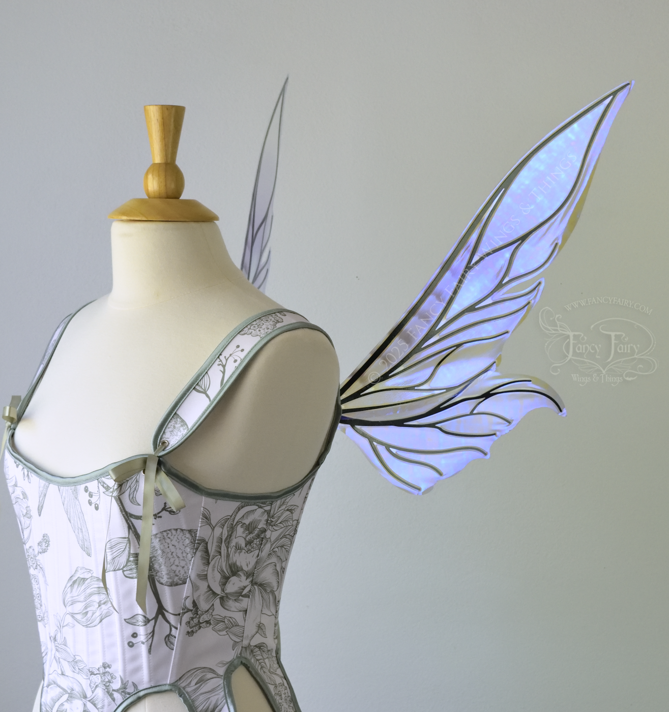 Iridescent & transparent violet fairy wings with elongated pointy upper panels and small leaf like lower panels, with black veins, right side view