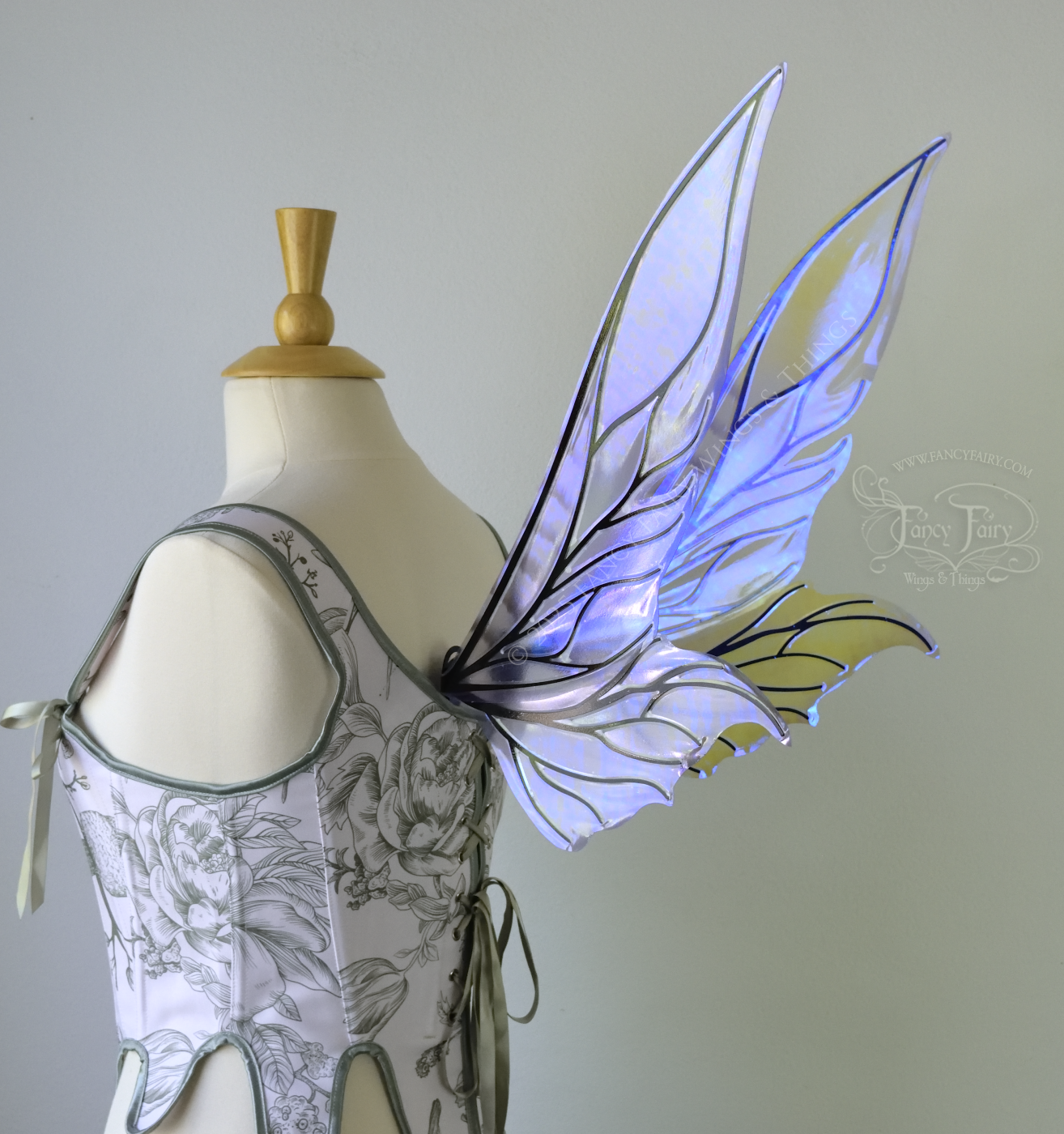Iridescent & transparent violet fairy wings with elongated pointy upper panels and small leaf like lower panels, with black veins, back 3/4 view