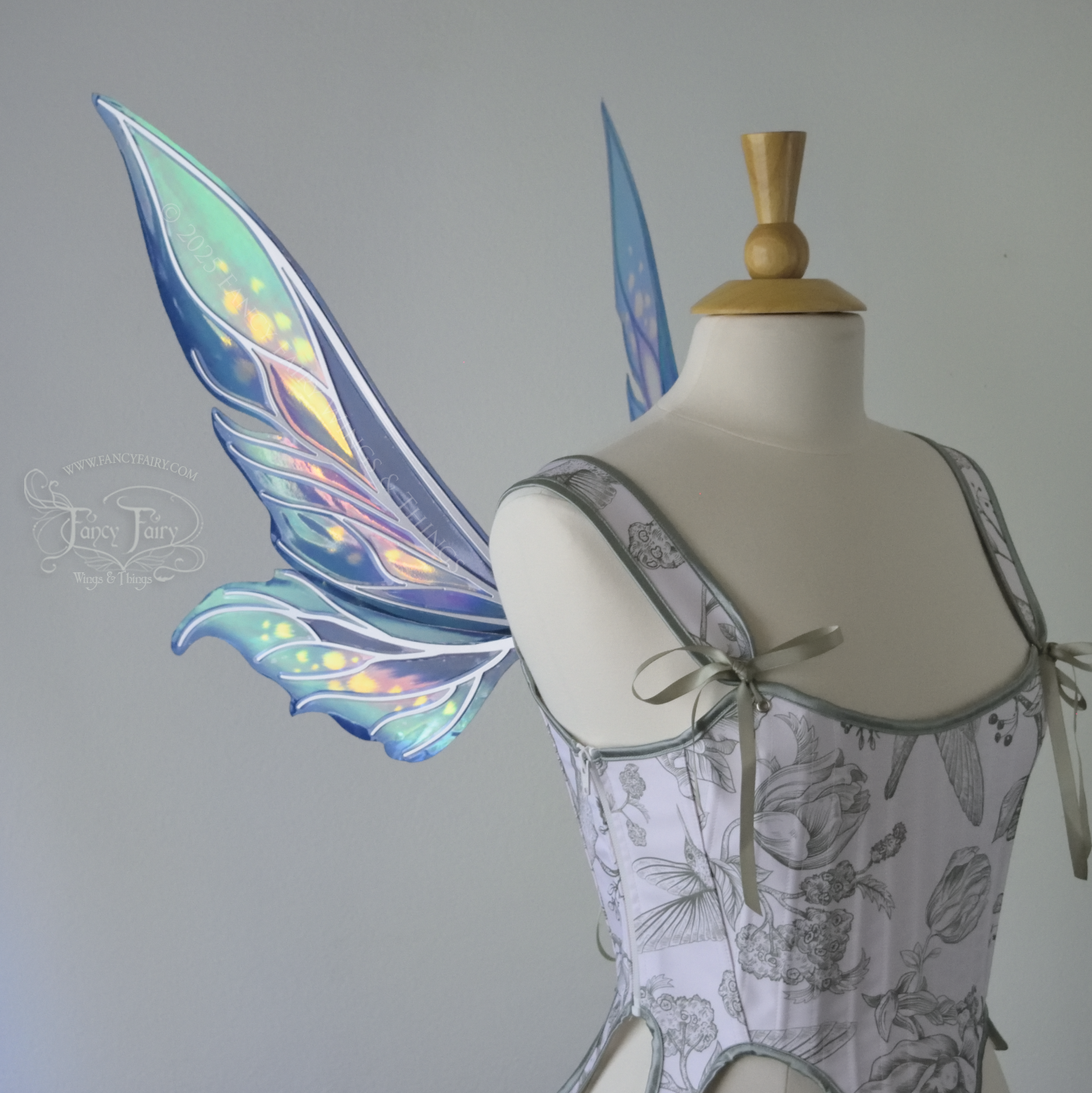 Iridescent elongated teal fairy wings with touches of purple and silver veins, left side view