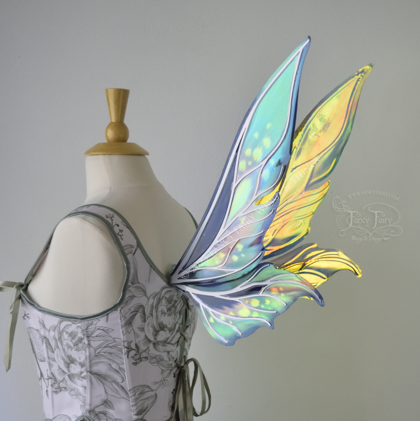 Iridescent elongated teal fairy wings with touches of purple and silver veins, right 3/4 back view