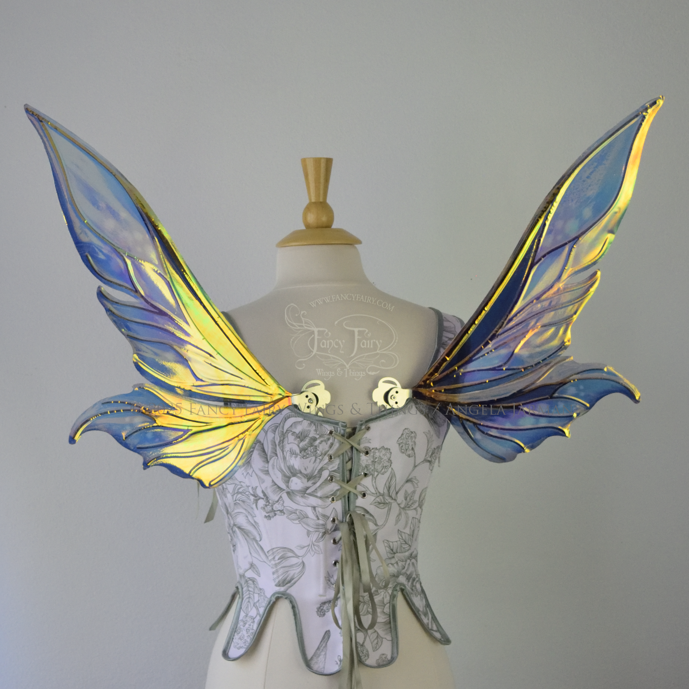 Iridescent elongated teal fairy wings with touches of purple and silver veins, back view