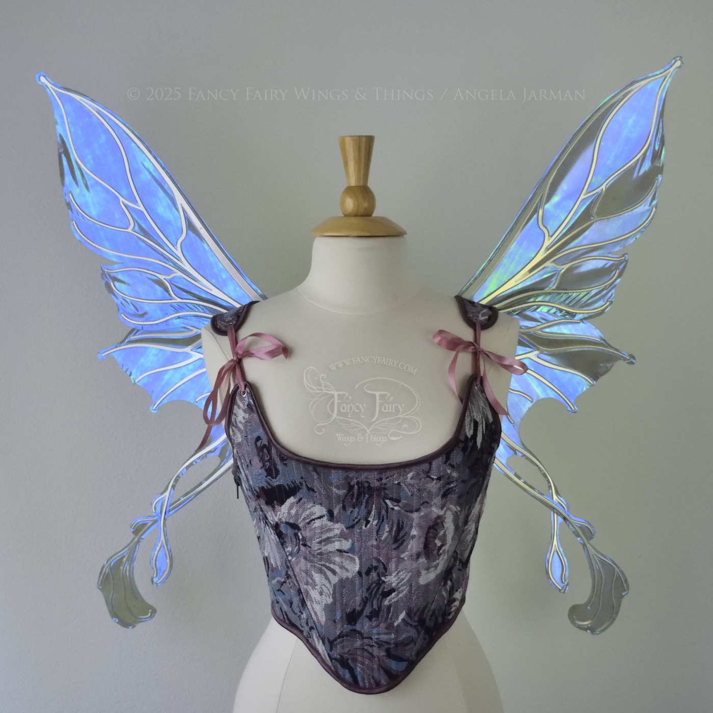 Transparent blue / purple / grey iridescent fairy wings with pointed upper tips and 2 swirling tails on the bottom panels with silver veins, worn on a dress form, front view