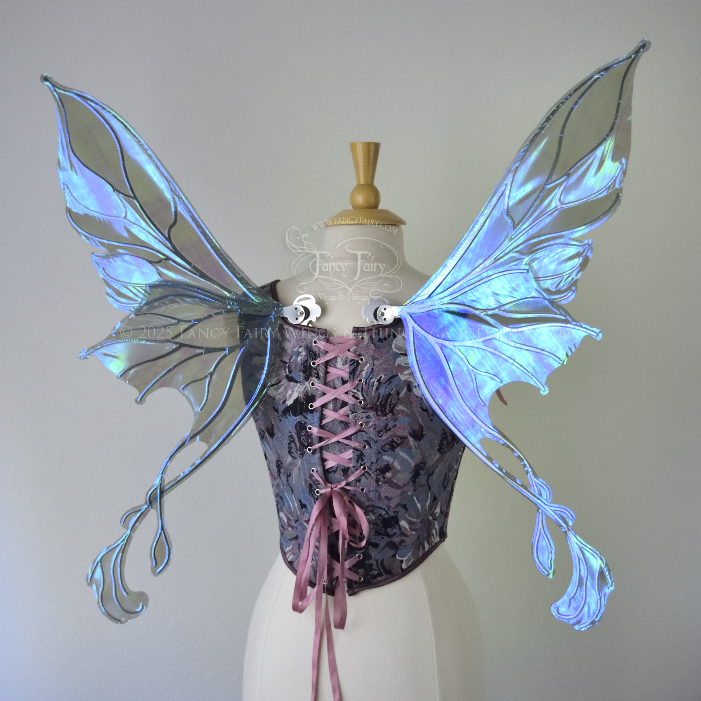 Transparent blue / purple / grey iridescent fairy wings with pointed upper tips and 2 swirling tails on the bottom panels with silver veins, worn on a dress form, back view
