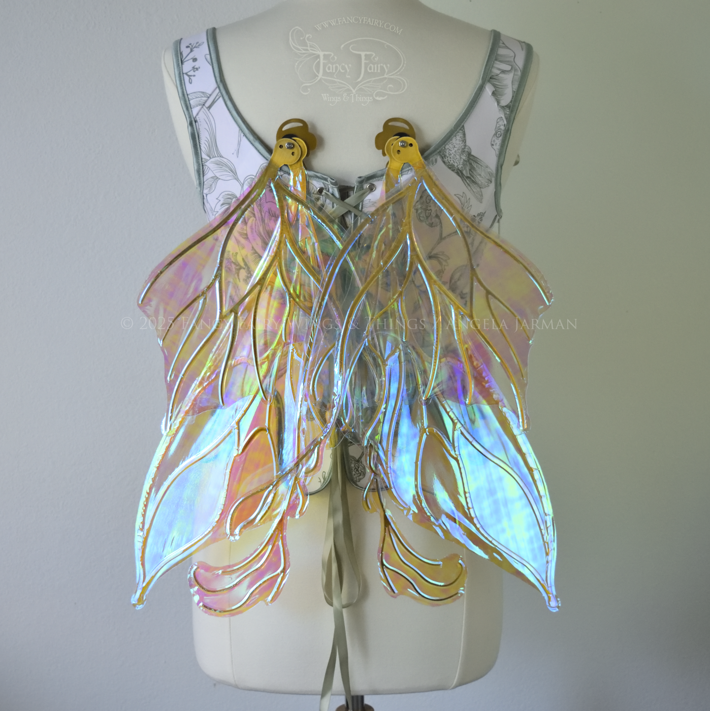 Transparent blue / green iridescent fairy wings with pointed upper tips and 2 swirling tails on the bottom panels with gold veins, worn on a dress form, back view, in resting position