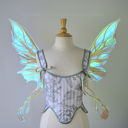 Transparent blue / green iridescent fairy wings with pointed upper tips and 2 swirling tails on the bottom panels with gold veins, worn on a dress form, front view