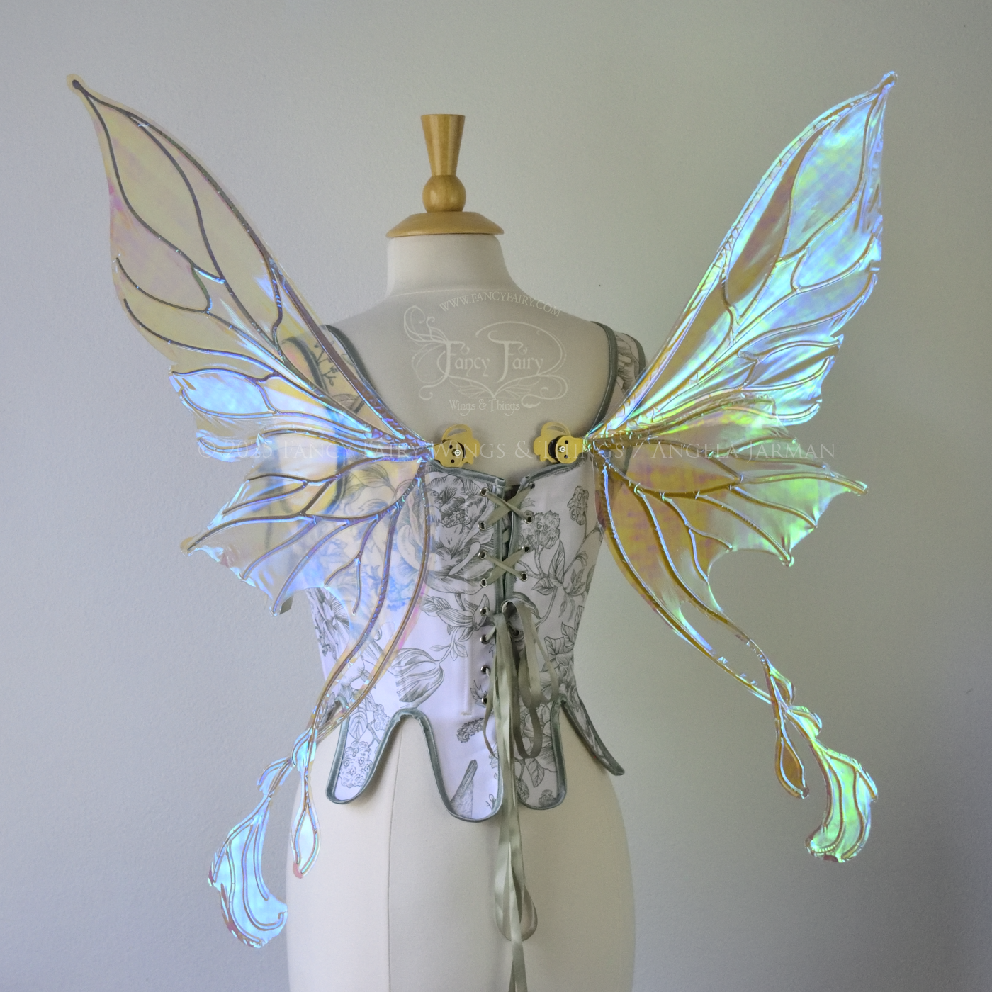 Transparent blue / green iridescent fairy wings with pointed upper tips and 2 swirling tails on the bottom panels with gold veins, worn on a dress form, back view