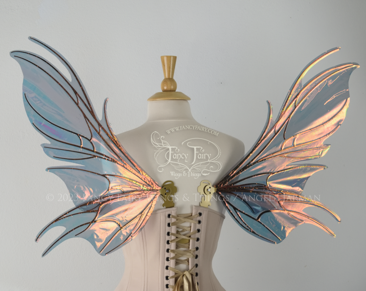 Back view of iridescent orange & dark grey/blue fairy wings with spikey veins, worn by a dress form