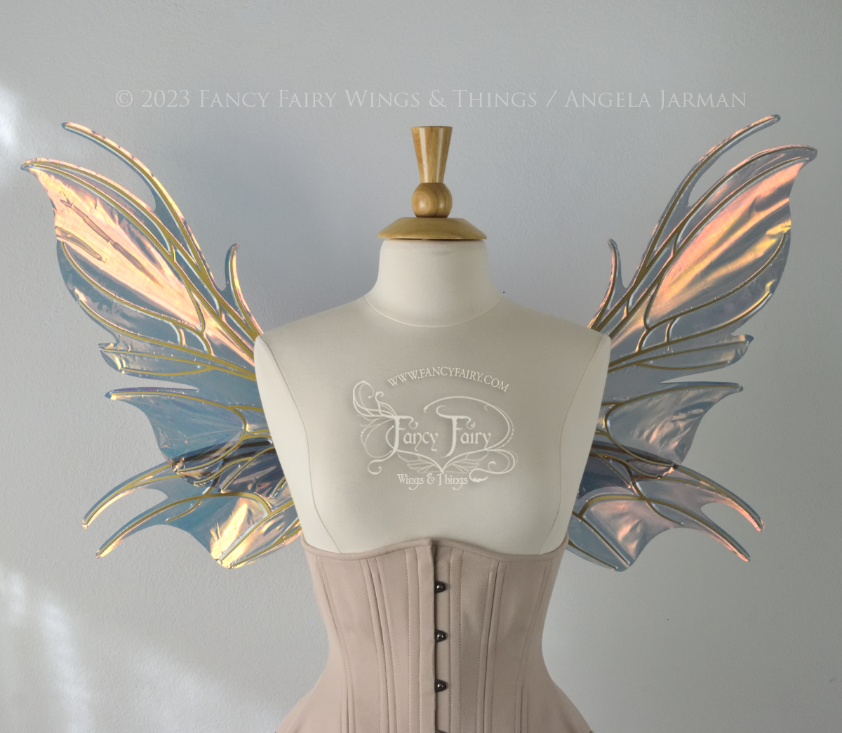 Front view of iridescent orange & dark grey/blue fairy wings with spikey veins, worn by a dress form