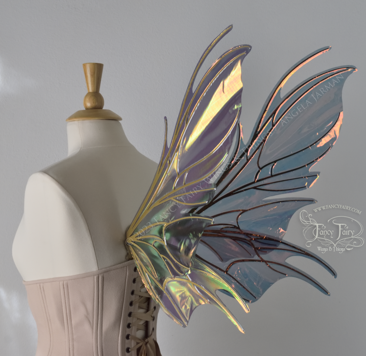 3/4 back view of iridescent orange & dark grey/blue fairy wings with spikey veins, worn by a dress form