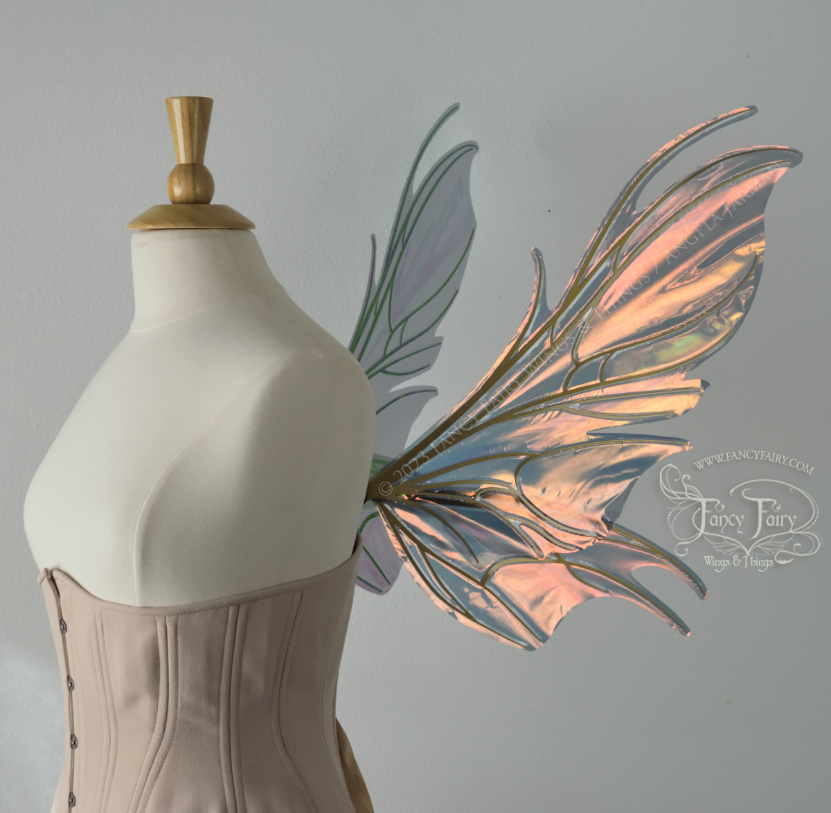 Right side view of iridescent orange & dark grey/blue fairy wings with spikey veins, worn by a dress form