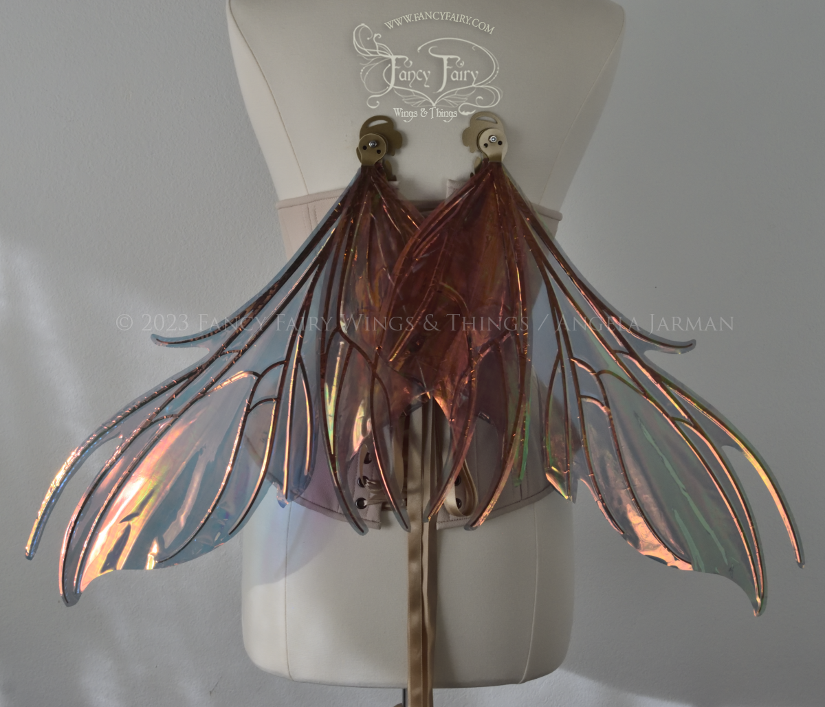 Back view of iridescent orange & dark grey/blue fairy wings with spikey veins, in resting position, worn by a dress form
