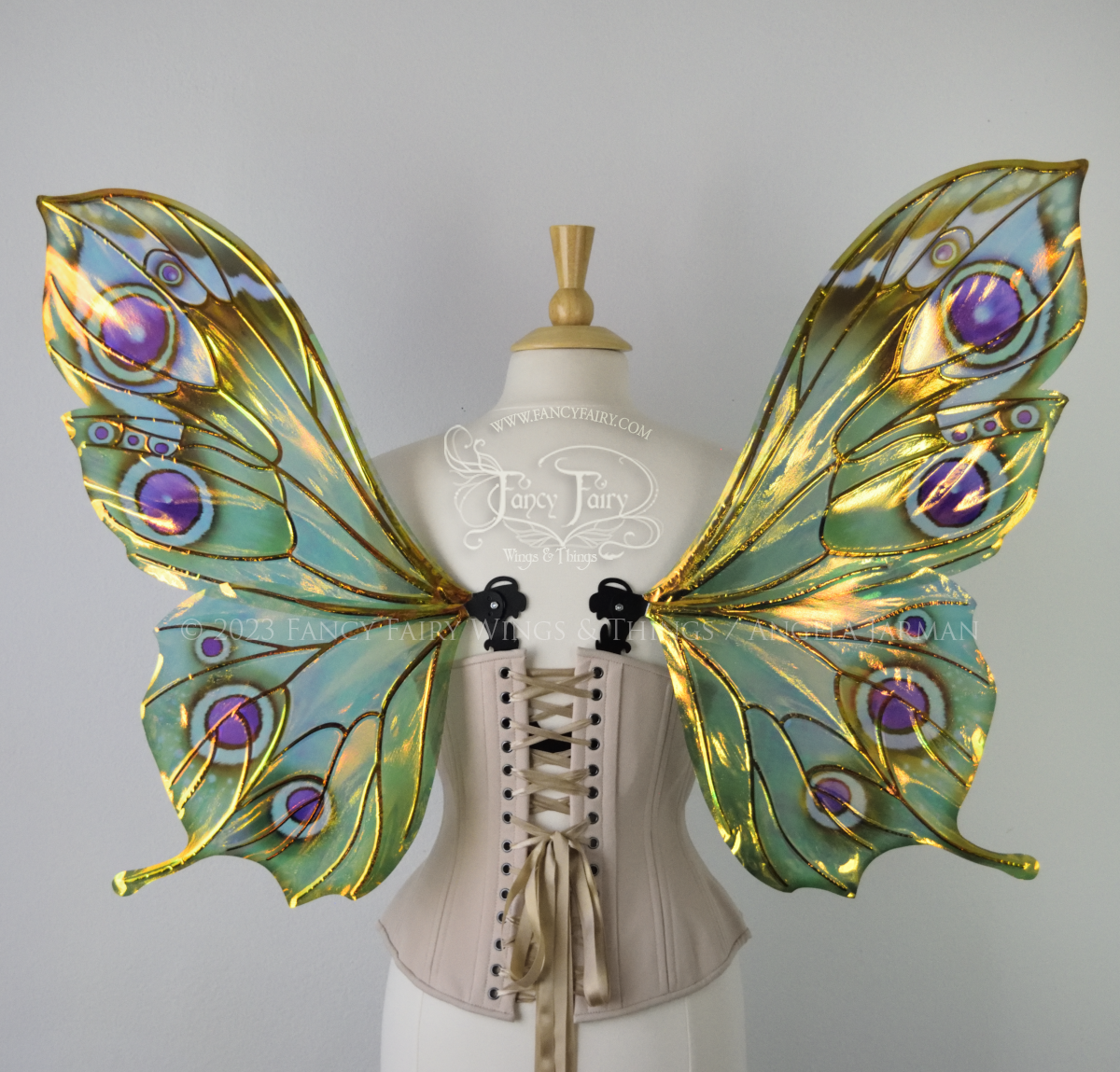 Back view of iridescent green, black and fuchsia costume fairy wings, worn on a dressform