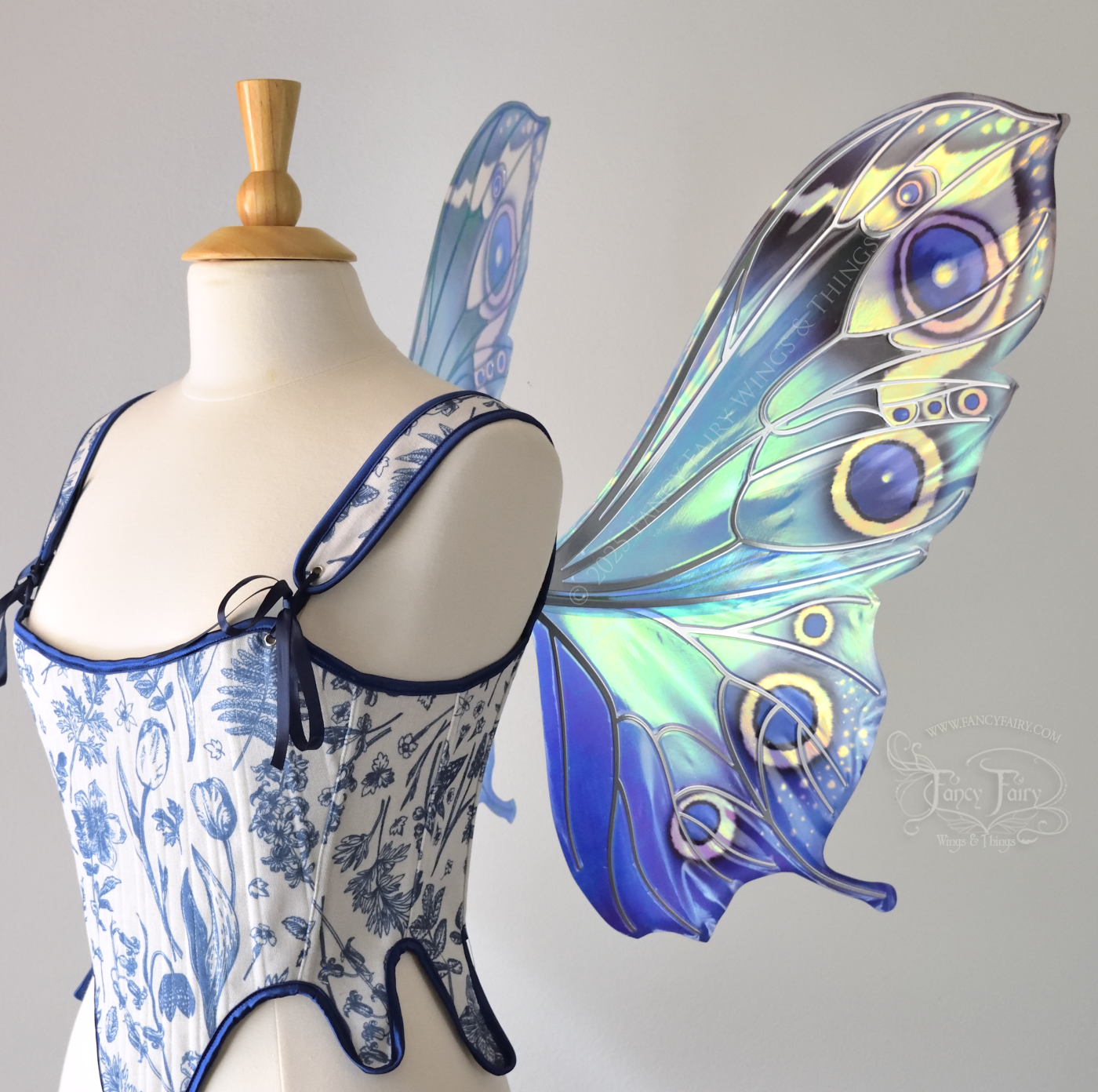 Blue iridescent butterfly shaped fairy wings with markings & 'eye' spots like the Buckeye butterfly, with silver veins, worn on a dress form, right side view