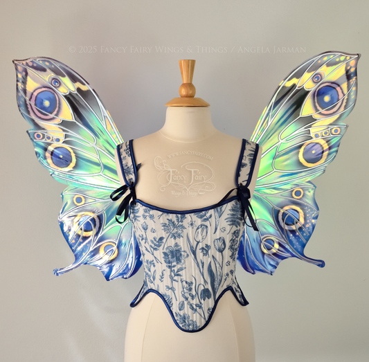 Blue iridescent butterfly shaped fairy wings with markings & 'eye' spots like the Buckeye butterfly, with silver veins, worn on a dress form, front view