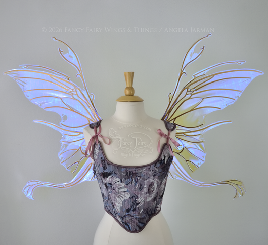 Large violet transparent iridescent fairy wings with a spikey profile and curvy tails on bottom, worn on a dress form, front view.