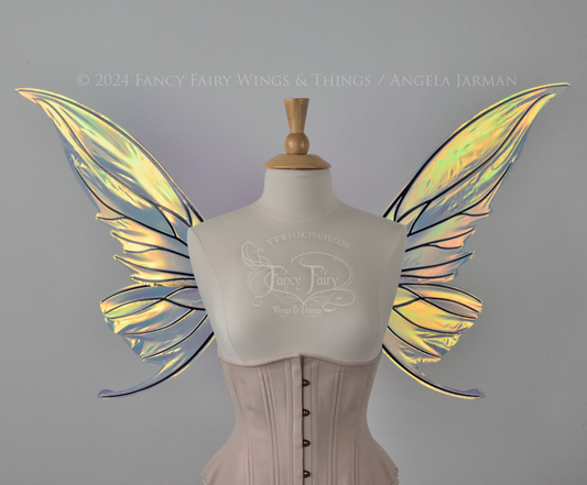 Front view of transparent iridescent fairy wings with slightly curved & pointed upper tips and 'tails' on the bottom panel that swoop up, the veins are black