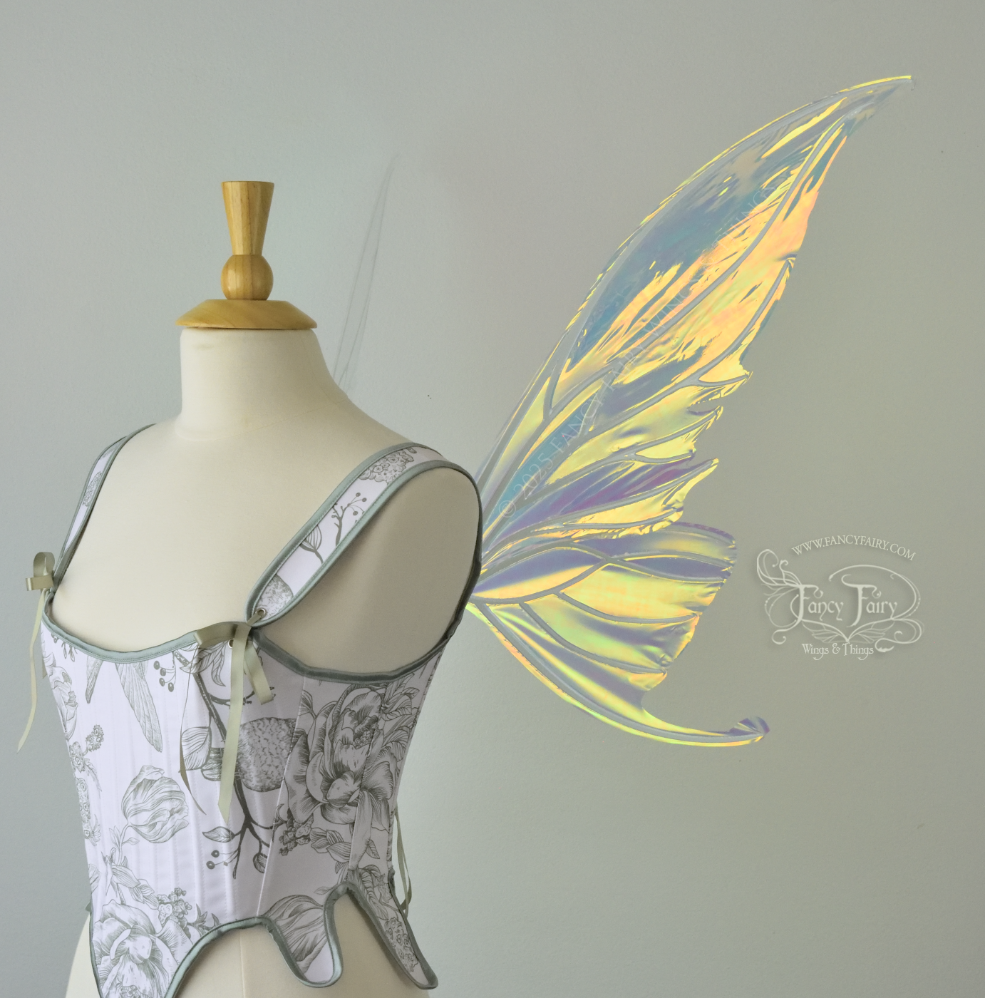 Iridescent transparent gold / orange / green fairy wings with small tails & white veins worn on a dress form, right side view