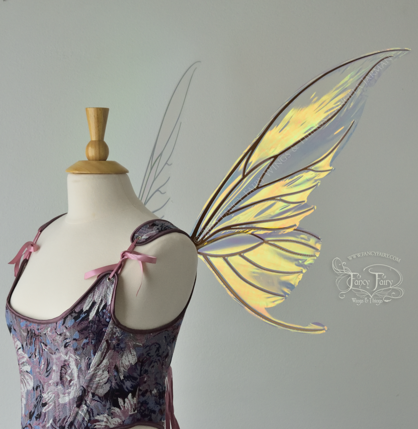 Iridescent transparent gold / orange / green fairy wings with small tails & black veins worn on a dress form, right side view