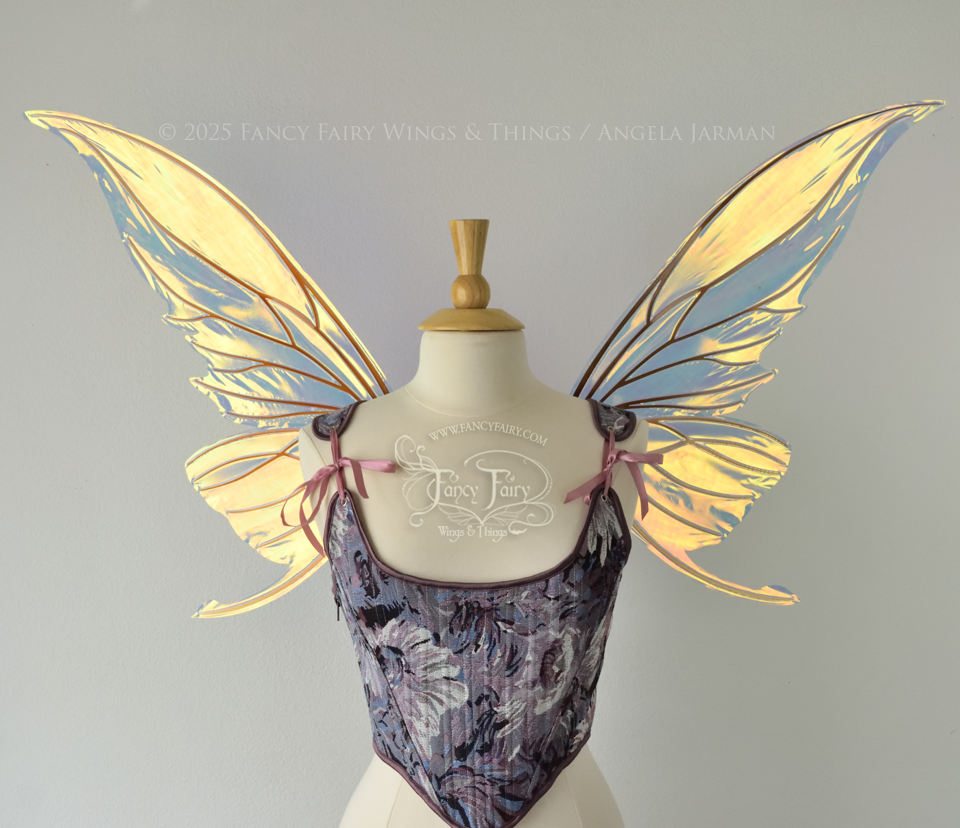 Iridescent transparent gold / orange / green fairy wings with small tails & black veins worn on a dress form, front view