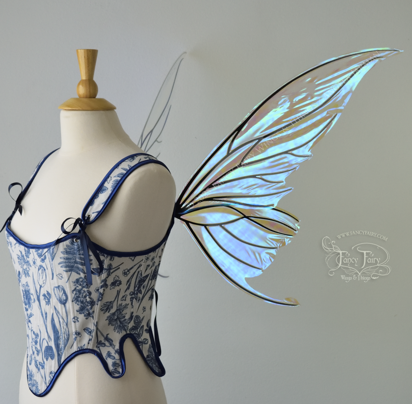 Iridescent transparent blue fairy wings with small tails & black veins worn on a dress form, right side view