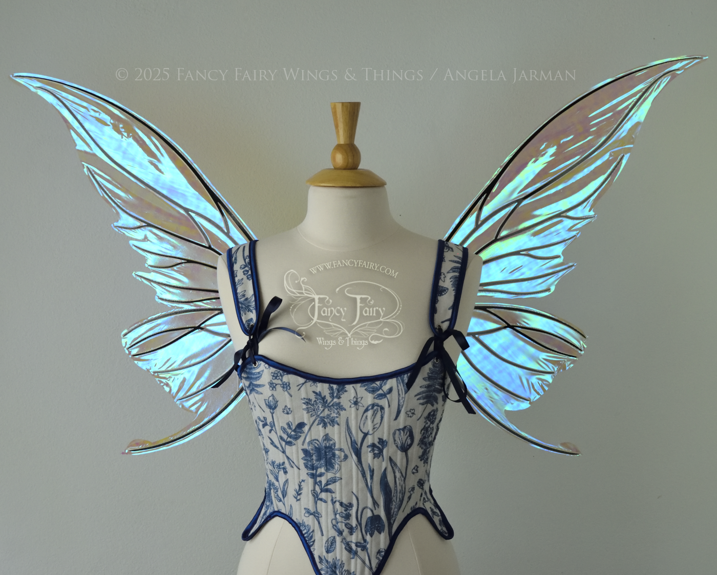 Iridescent transparent blue fairy wings with small tails & black veins worn on a dress form, front view