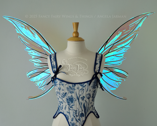 Iridescent transparent blue fairy wings with small tails & black veins worn on a dress form, front view