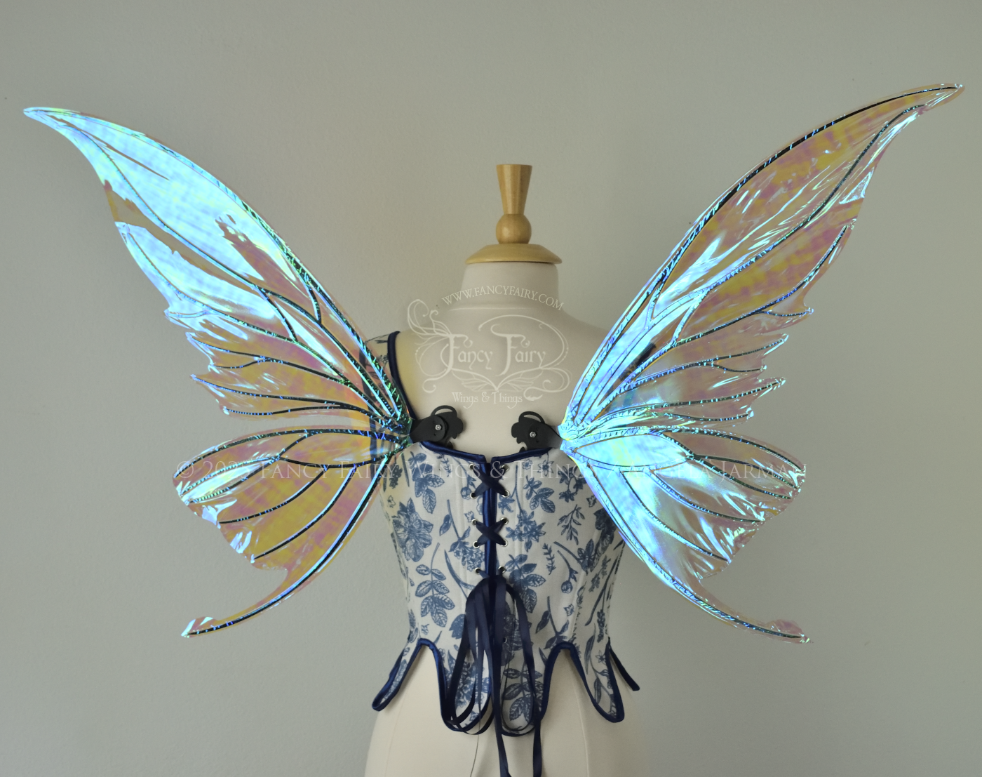 Iridescent transparent blue fairy wings with small tails & black veins worn on a dress form, back view